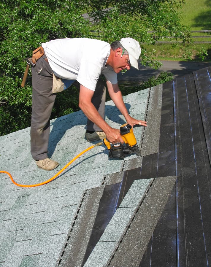 Professional Fixing a Roof After a Storm
